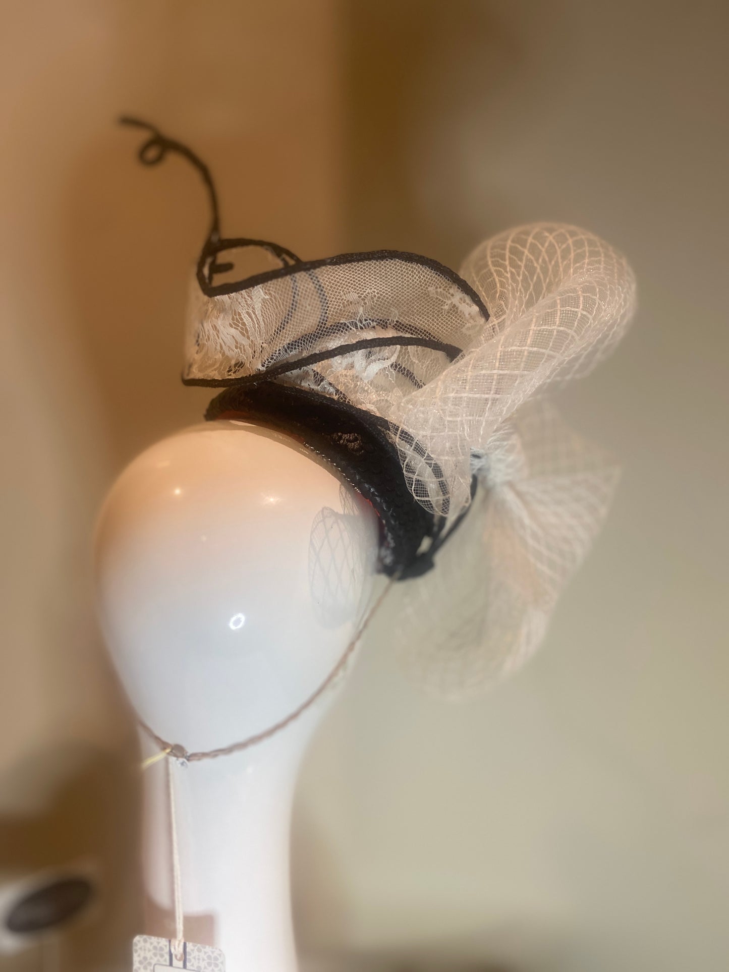 Black pleather button fascinator with swirls in white lace and crinoline